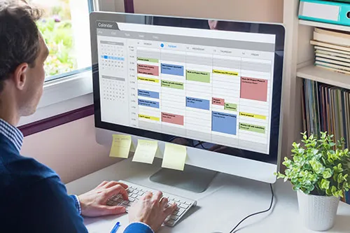 man at computer looking at his schedule